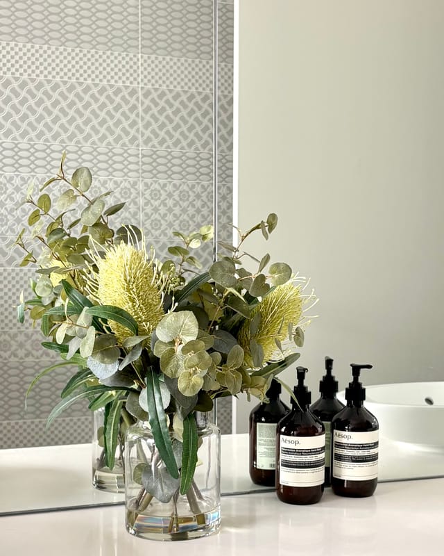 Powder room vanity with Aesop hand wash and banksia in a glass vase